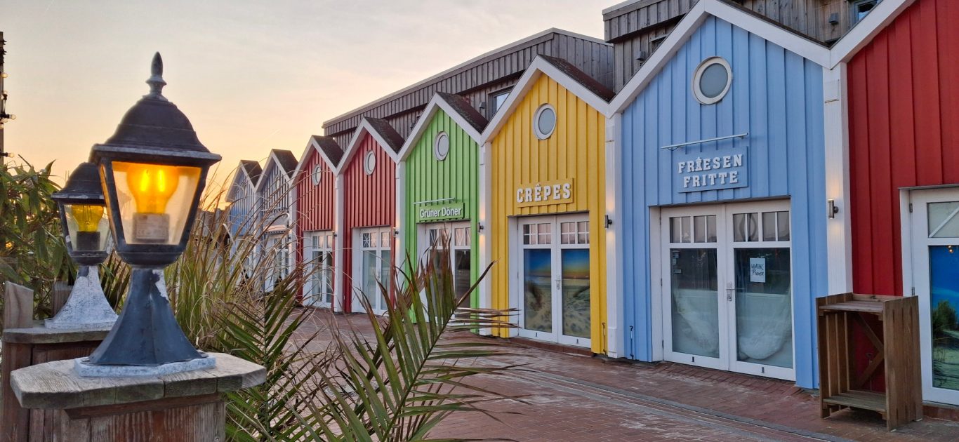 Ruhig und beschaulich. Die bunten Buden am Abend Die bunten Buden an der Strandpromenade von Langeoog in der Abndämmerung bei wolkenfreiem Himmel